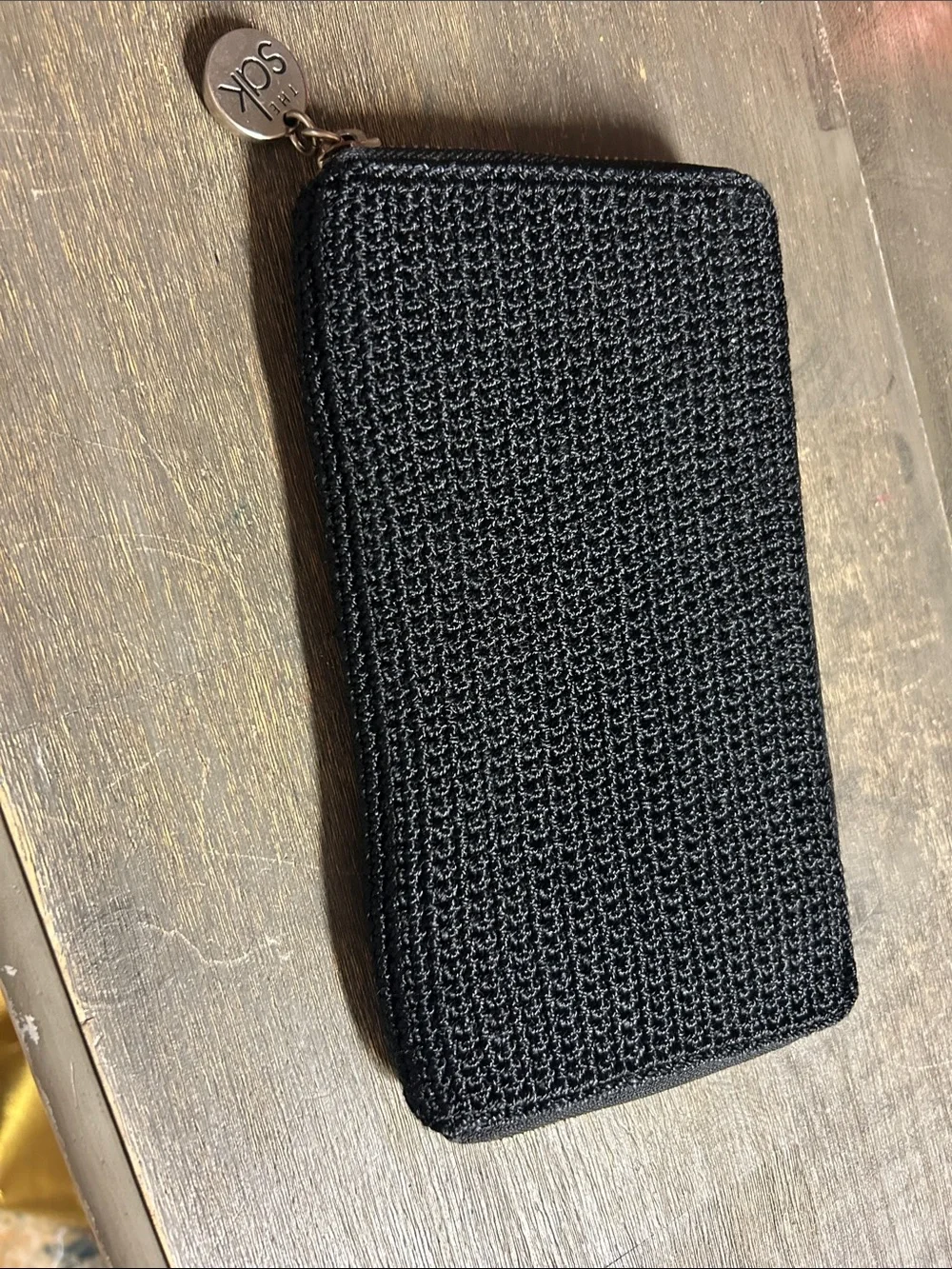 The Sak Black Crochet Zip Wallet with Logo Charm Accordion Style